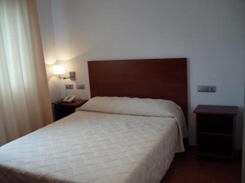 sypialnia z białym łóżkiem i 2 szafkami nocnymi w obiekcie Valcarce Urbasa w mieście Olazagutía