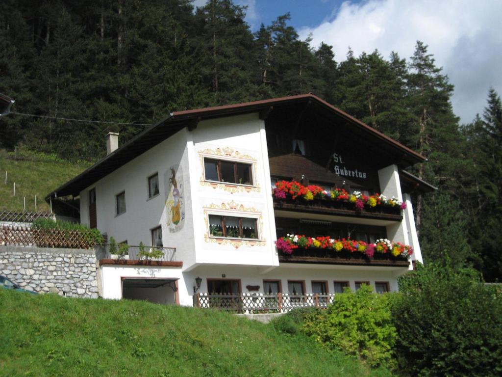 a white building with flower boxes on it at St. Hubertus in Pettneu am Arlberg