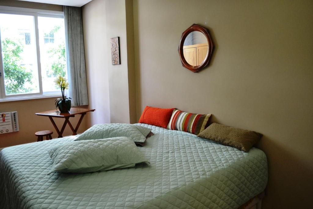 1 dormitorio con 1 cama con espejo en la pared en Studio Copacabana, en Río de Janeiro