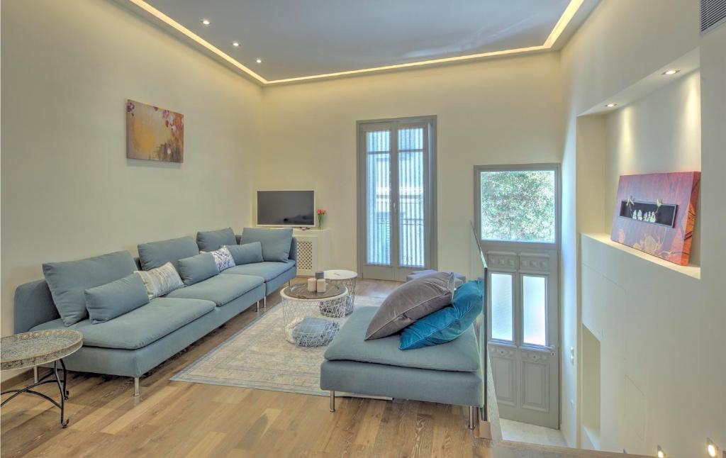 a living room with a blue couch and a tv at Stylish and cozy house in Athens, Plaka in Athens