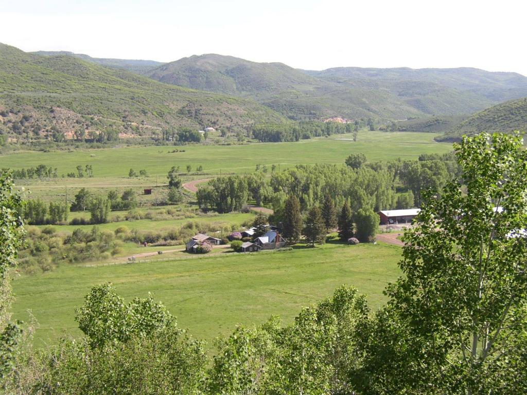 a view of a green field with mountains in the background at Rolling R Guest Ranch in Meeker