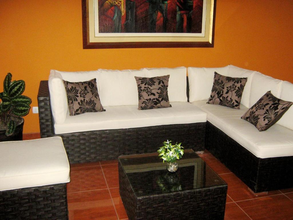 ein Wohnzimmer mit 2 weißen Sofas und einem Tisch in der Unterkunft apartamentos Los cedros in Lima