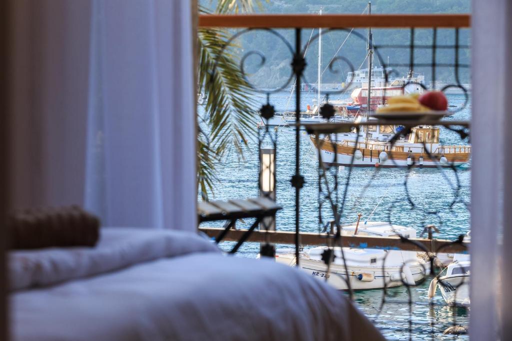 a bedroom with a view of a boat in the water at Seafront rooms Koluna in Komiža