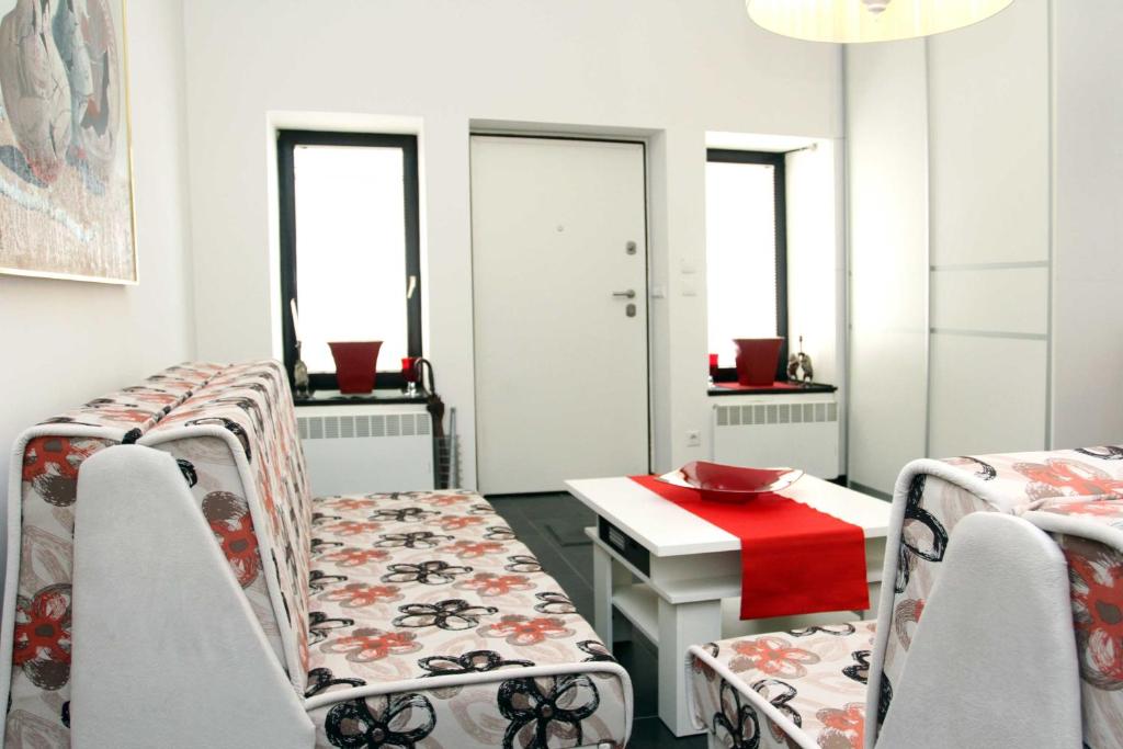 a room with two chairs and a table with a red plate on it at Epicentar in Sarajevo