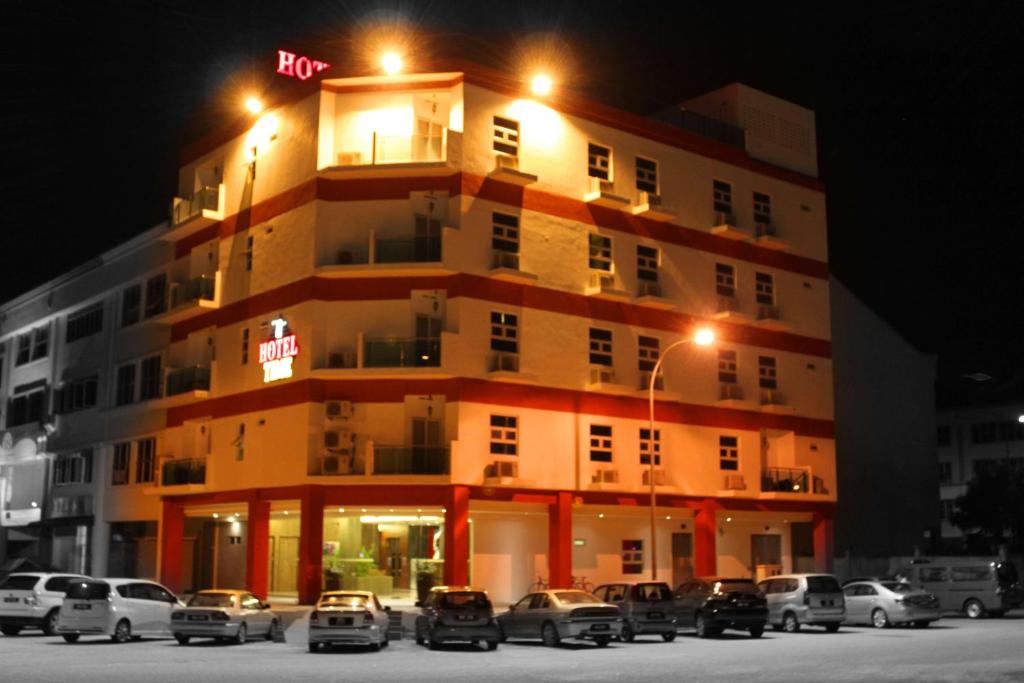 un edificio con coches estacionados frente a él en Hotel Time Boutique Nilai en Nilai