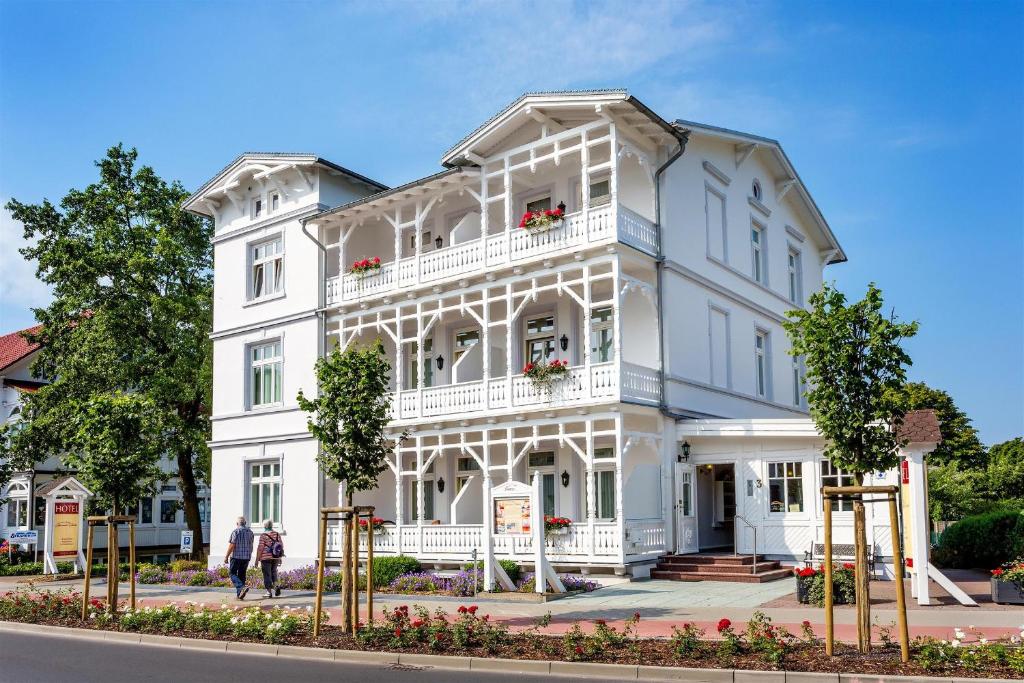 ein weißes Gebäude mit Blumen davor in der Unterkunft Hotel Garni Getreuer Eckart in Binz