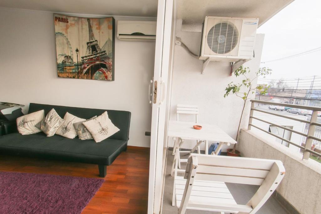 sala de estar con sofá y balcón en Apartamento hogareño, en Santiago