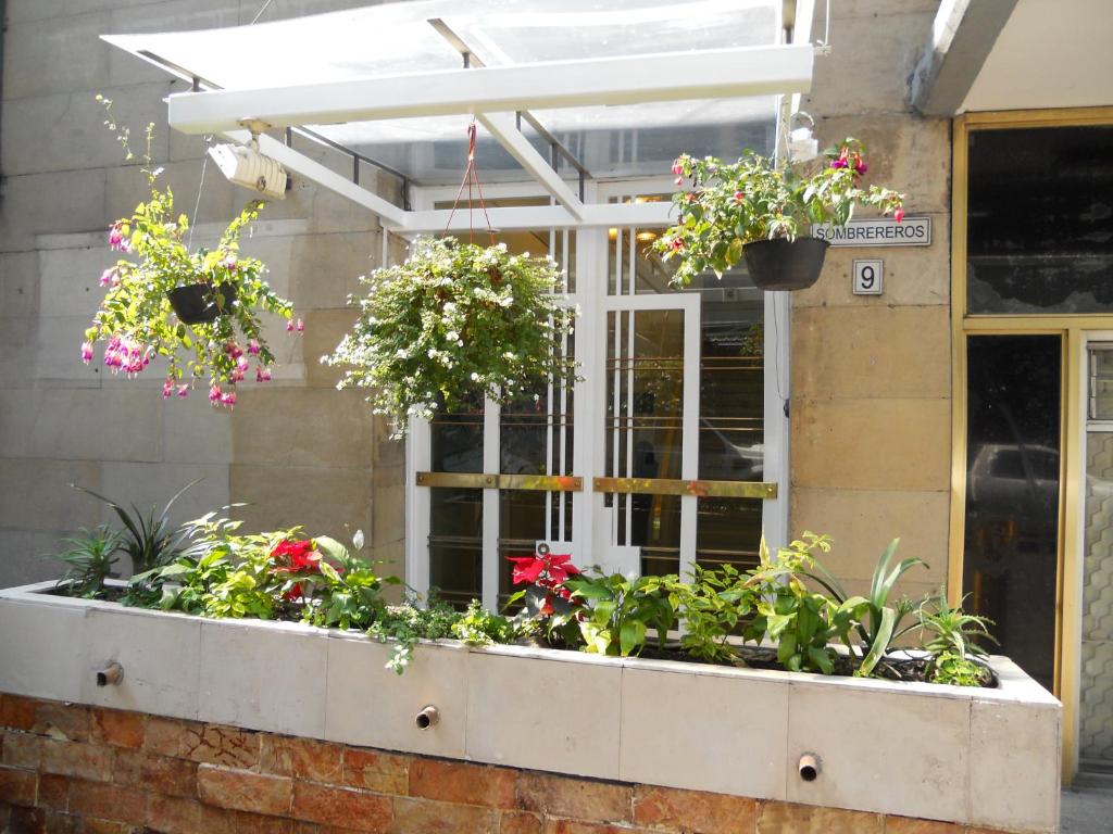 een raamkozijn met bloemen en planten erin bij Apartamentos Hotel Avilla in Mexico-Stad