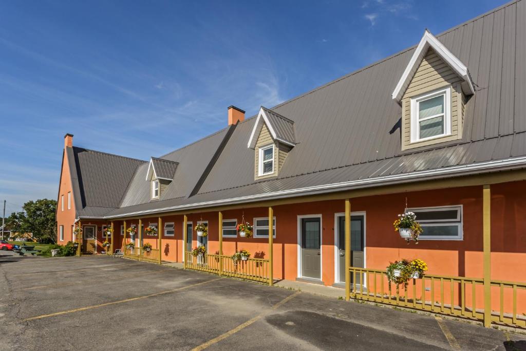 un bâtiment orange avec un toit gris dans l'établissement Auberge de L'Anse, à Rivière-du-Loup