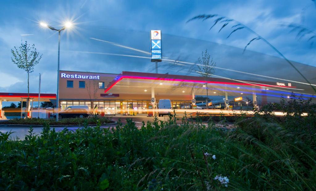 a supermarket with a lit up building at night at Zum Eichenzeller in Eichenzell