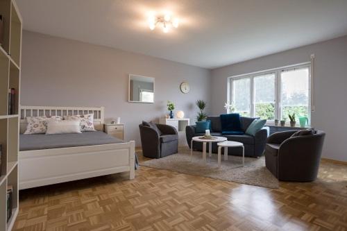 a bedroom with a bed and a couch and chairs at Ferienwohnung im Aalbachtal - Uettingen bei Würzburg in Uettingen