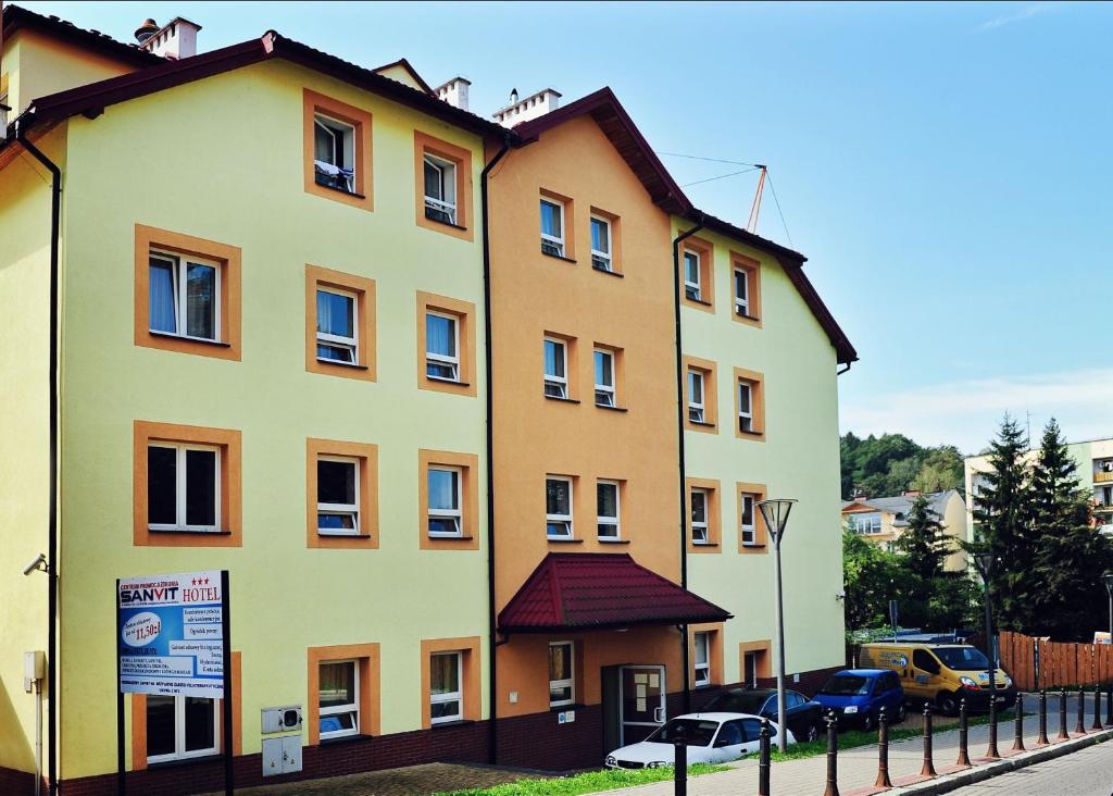 ein großes gelbes Gebäude an der Straßenseite in der Unterkunft Hotel SANVIT RESTAURACJA & SPA in Sanok