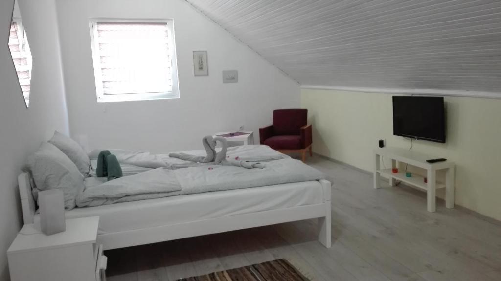 um quarto branco com uma cama e uma televisão em Apartment Dixy em Belgrado