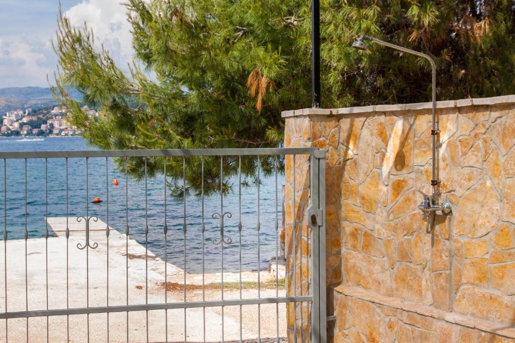 eine Steinmauer mit einem Tor neben dem Wasser in der Unterkunft Ricci Apartment in Trogir