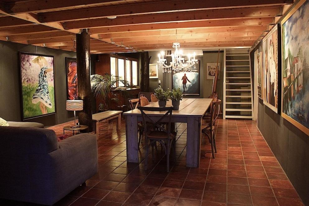 羊角村的住宿－De Galeriet Giethoorn，一间带桌椅和绘画的用餐室