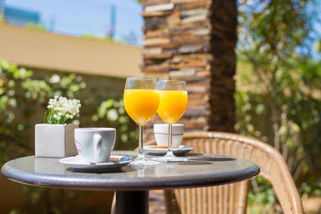 two glasses of orange juice sitting on a table at Blue Waves Resort in Malinska