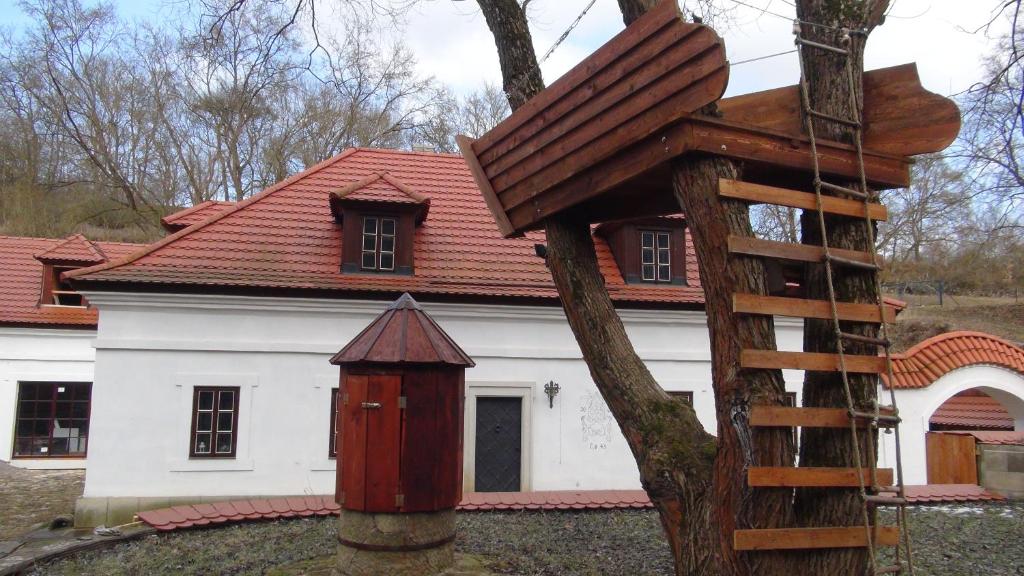 una casa blanca con techo rojo y un árbol en 14 Century Water Mill, en Mořina