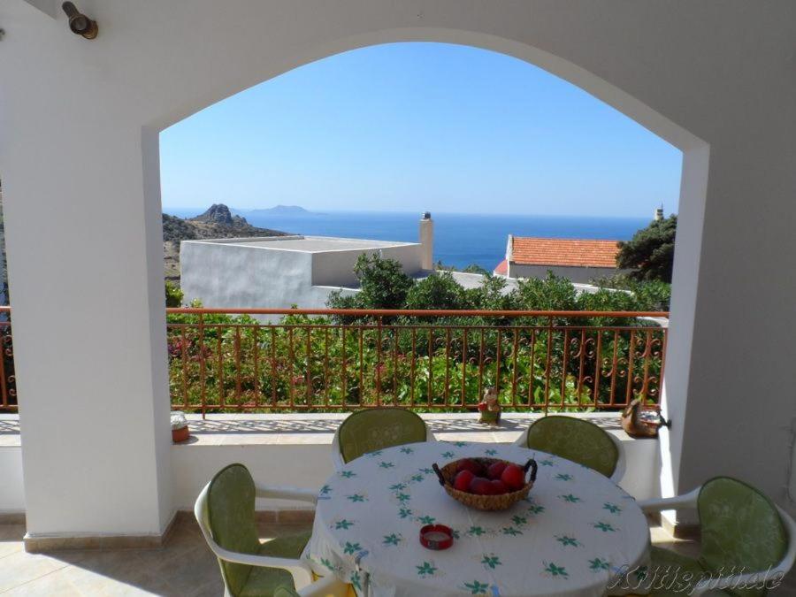 a table with a bowl of fruit on a balcony at Liolio's Manor in Agalianós