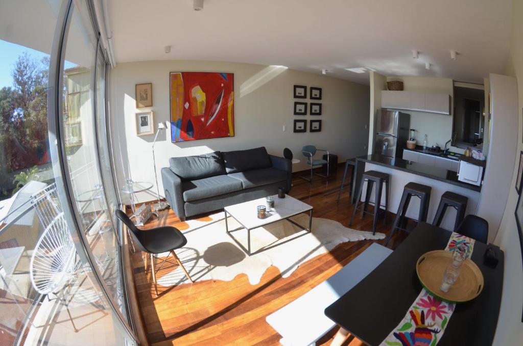 Lofts Vistalegre في فالبارايسو: غرفة معيشة مع أريكة ومطبخ