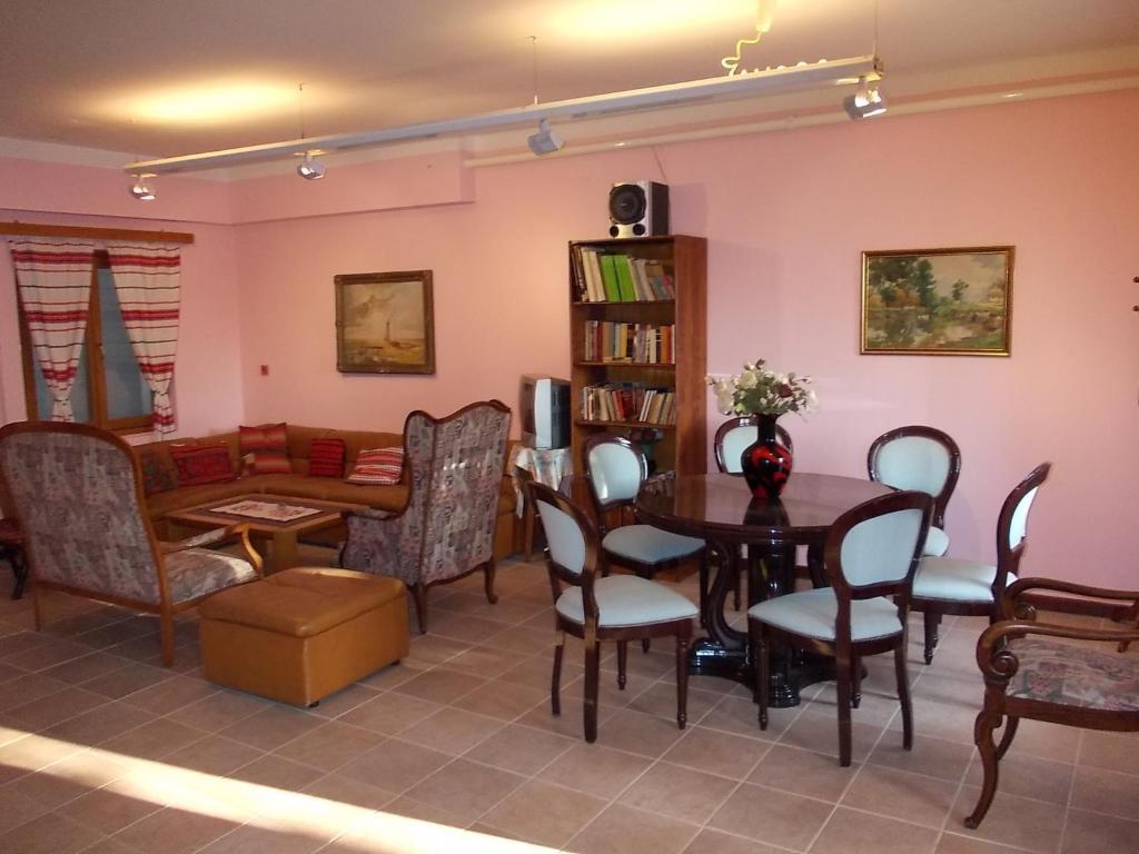 een woonkamer met een tafel en stoelen en een bank bij Puszta Hotel in Berekfürdő