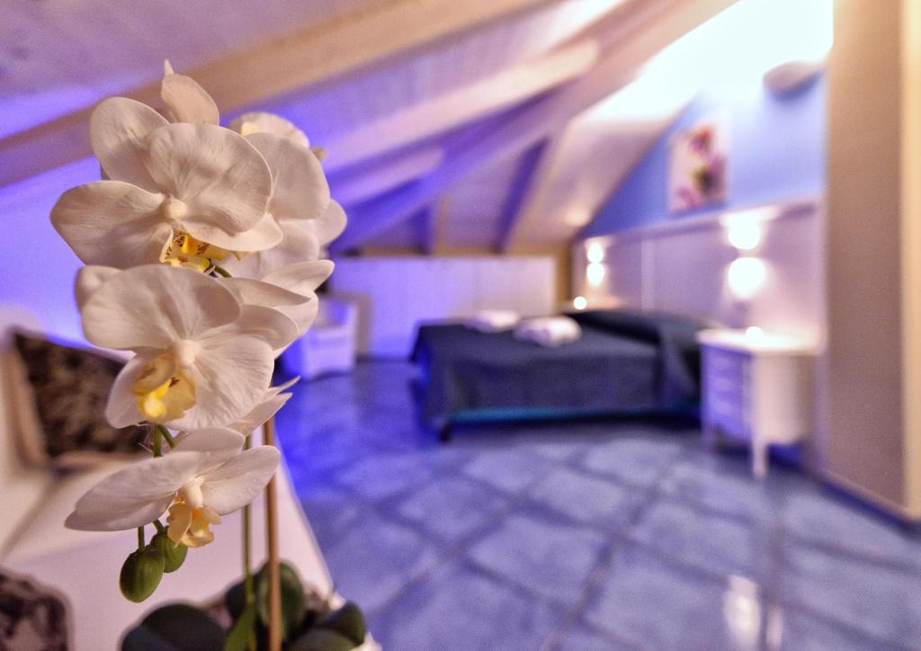 una camera con un letto e fiori bianchi in un vaso di Residenza Vinci Room & Suite a Pizzo