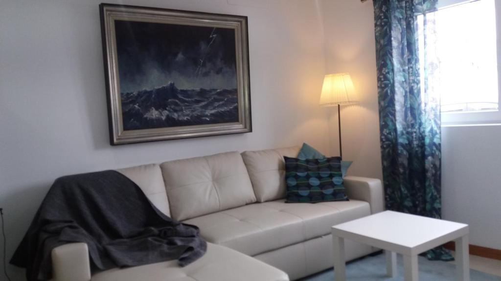 ein Wohnzimmer mit einem weißen Sofa und einem Tisch in der Unterkunft Appartement Espinho in Espinho