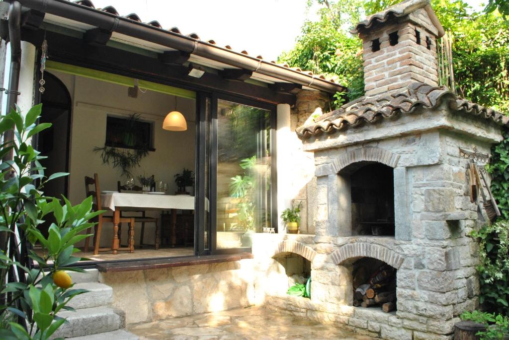 a patio with a stone fireplace in front of a house at Old Town Uspon in Pula