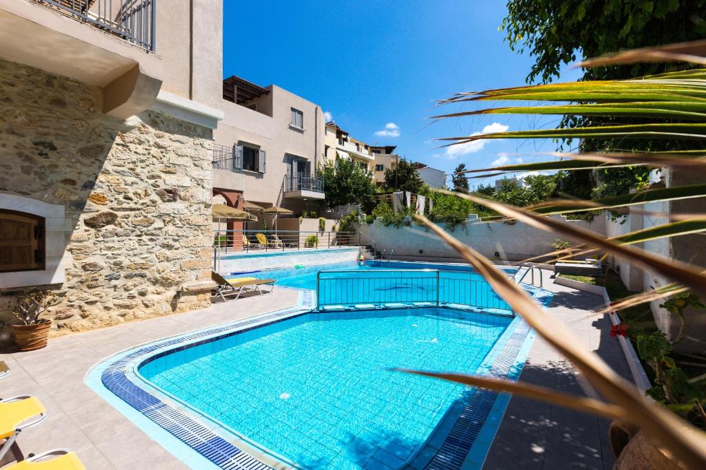 ein Schwimmbad in der Mitte eines Gebäudes in der Unterkunft Philoxenia Apartments in Panormos