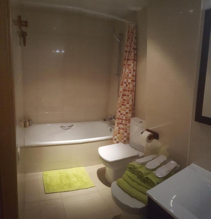 uma casa de banho com um WC, uma banheira e um lavatório. em tarragonaapartments arrabassada beach em Tarragona
