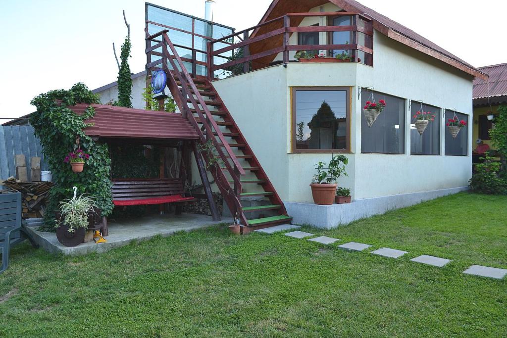 a house with a staircase and a bench in the yard at Casa Chitu in Murighiol