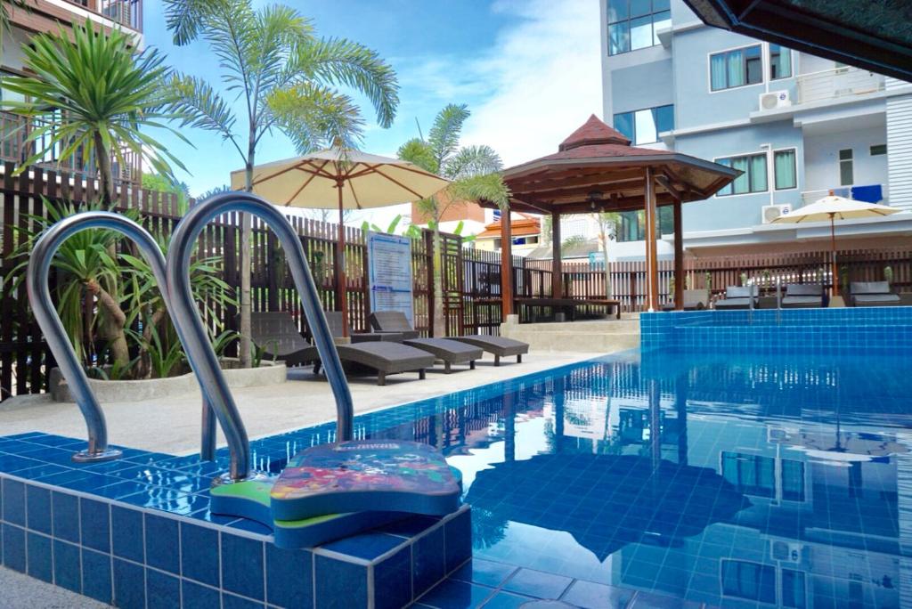 - une piscine avec des chaises et des parasols à côté d'un bâtiment dans l'établissement Pranee Amata, à Koh Tao