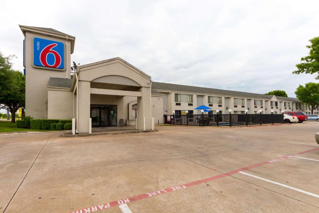 un edificio con un estacionamiento delante de él en Motel 6-Dallas, TX - Northeast, en Garland