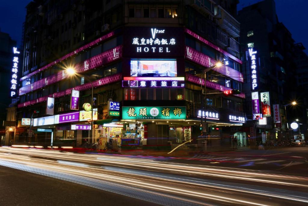 een gebouw met neonborden in een stad 's nachts bij V-one Vogue Hotel in Taipei