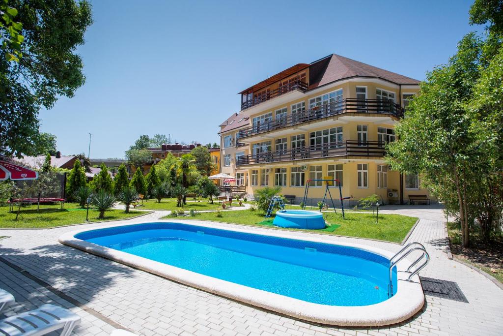 a house with a swimming pool in front of a building at Hotel Staraya Khosta in Khosta