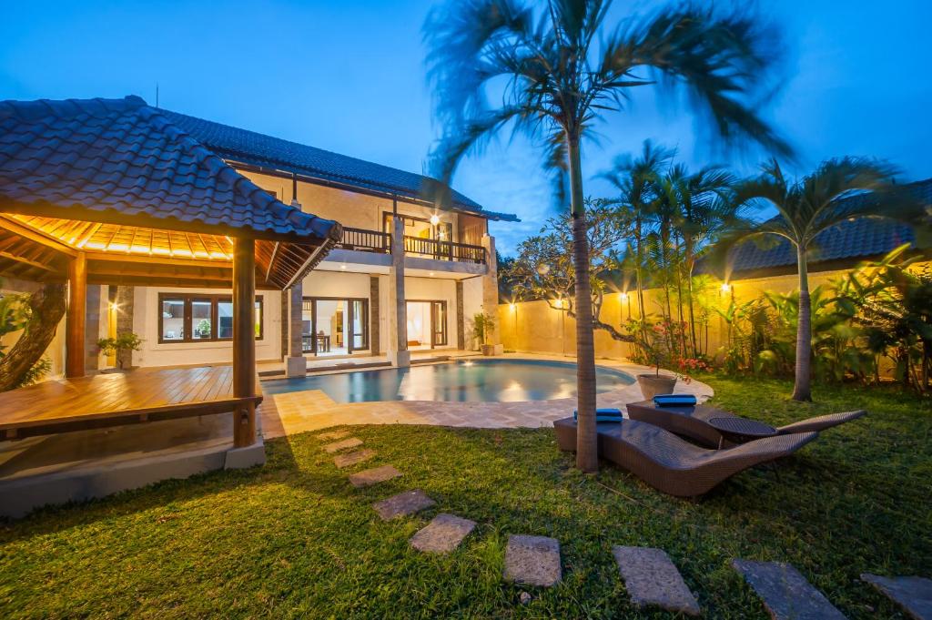 een villa met een zwembad en een huis bij Casa Priya Seminyak in Kerobokan