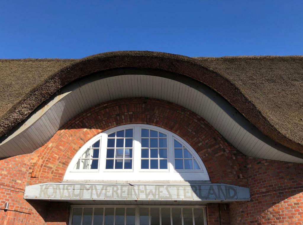 a window on the side of a brick building at Alter Konsumverein App N°9 in Westerland