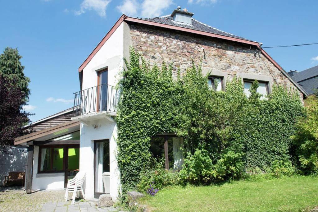 an old stone house with ivy on the side of it at Ancien relais de la diligence in Sart