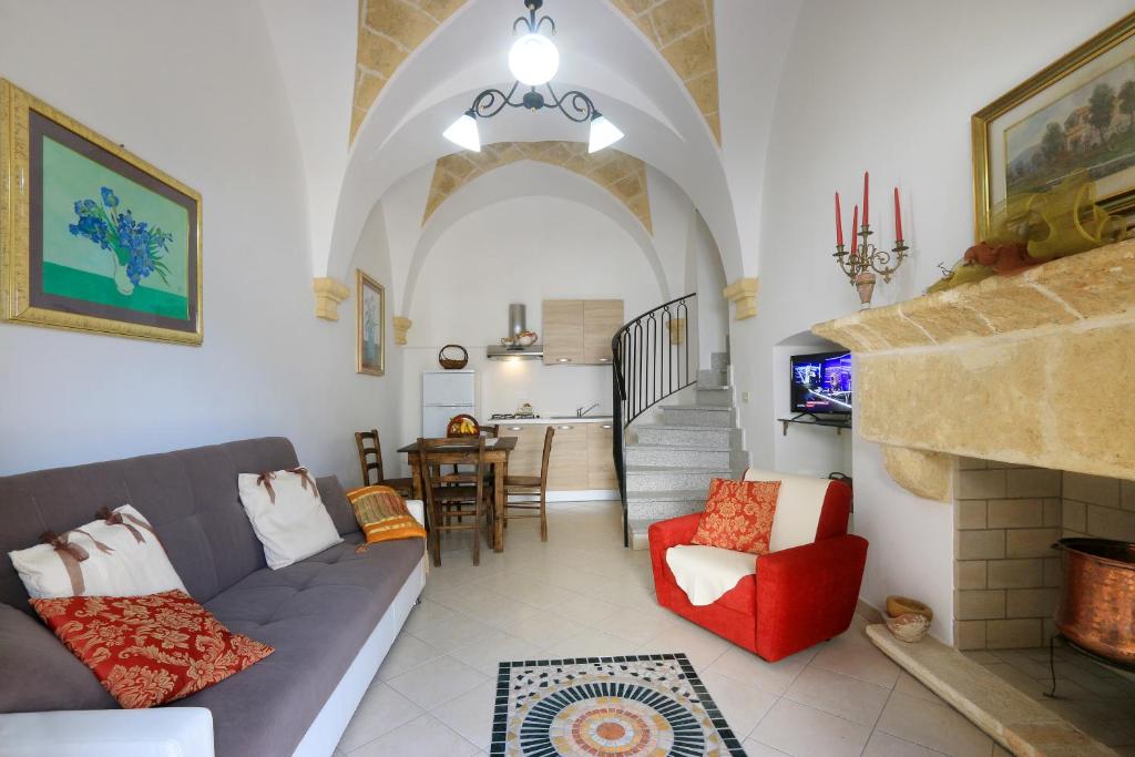 ein Wohnzimmer mit einem Sofa und einem Kamin in der Unterkunft Corte Antica in Presicce
