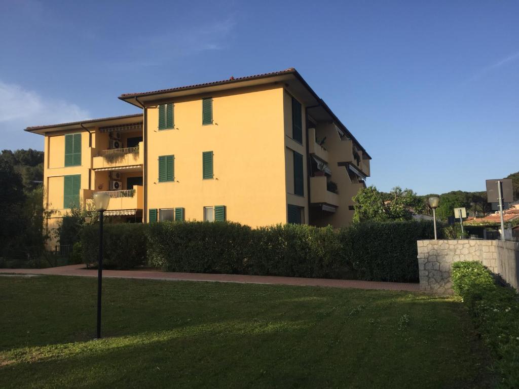 un edificio con un césped verde delante de él en CasaRoberta, en Marina di Campo