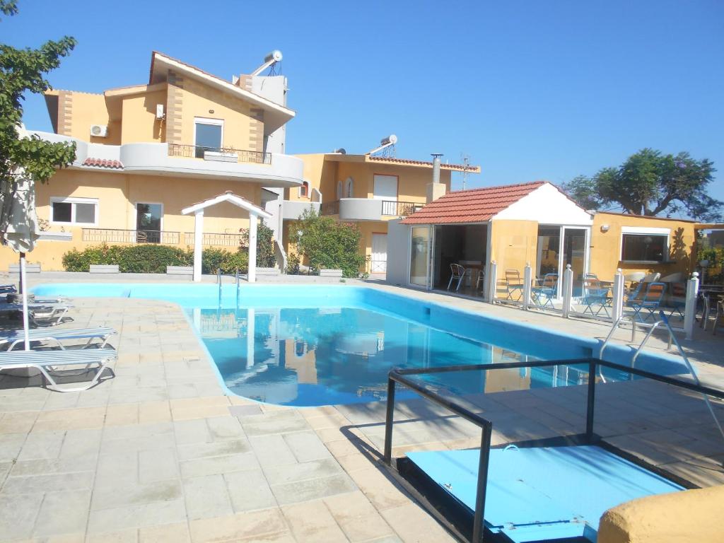 einem großen Pool vor einem Gebäude in der Unterkunft Villa Sofia in Ialyssos