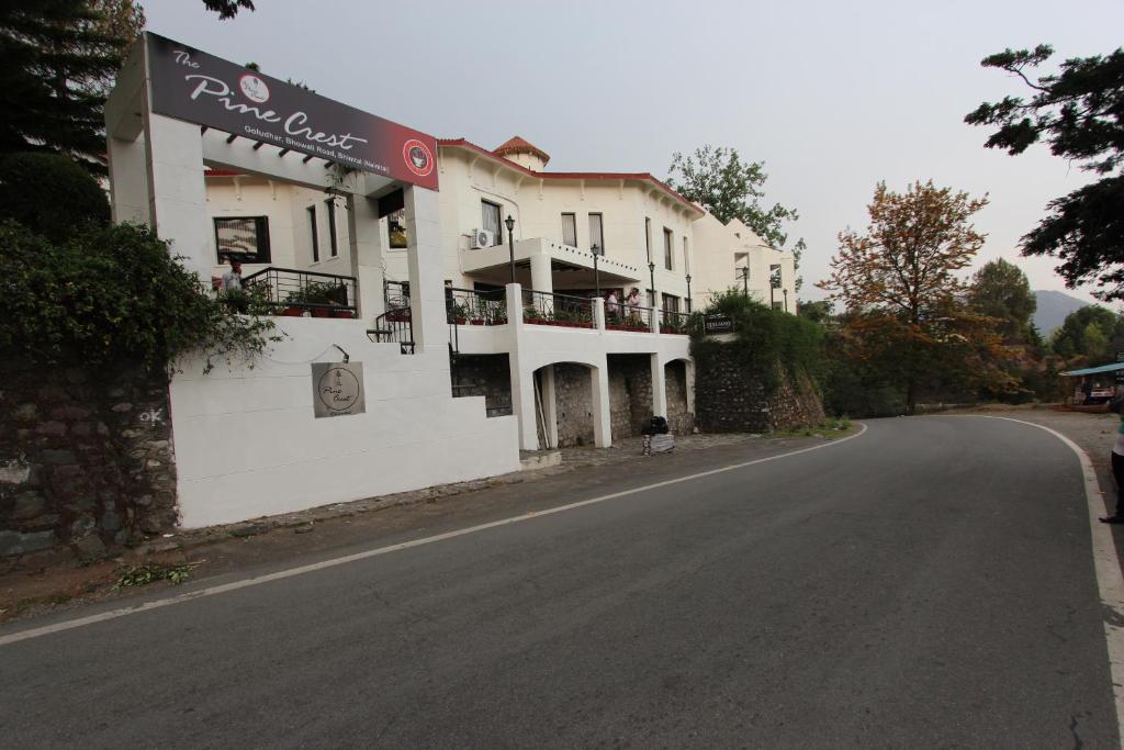 ein Gebäude am Straßenrand in der Unterkunft The Pine Crest Resort Bhimtal in Bhīm Tāl