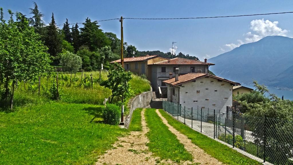 een huis in een veld naast een hek bij Casa Giacomina garden and Lake view by Gardadomusmea in Tremosine Sul Garda