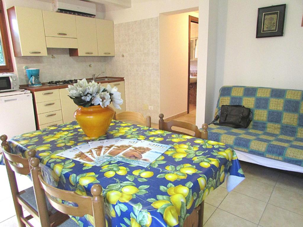 una cucina con tavolo e vaso di fiori di Annie a Bibione