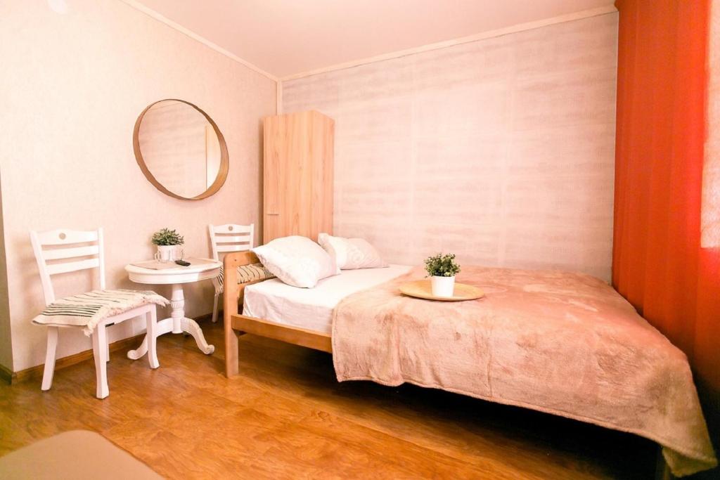 烏蘭烏德的住宿－舒瑪克酒店，一间卧室配有一张床、一张桌子和一面镜子
