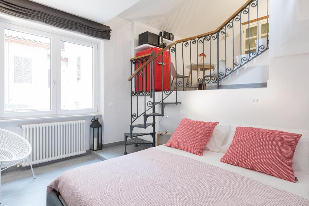 een slaapkamer met een bed en een wenteltrap bij Quiet pied a terre with terrace in Borgo Pio in Rome