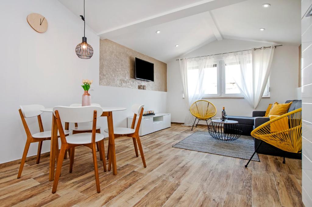 uma sala de jantar e sala de estar com mesa e cadeiras em Apartments Vanesa em Rovinj