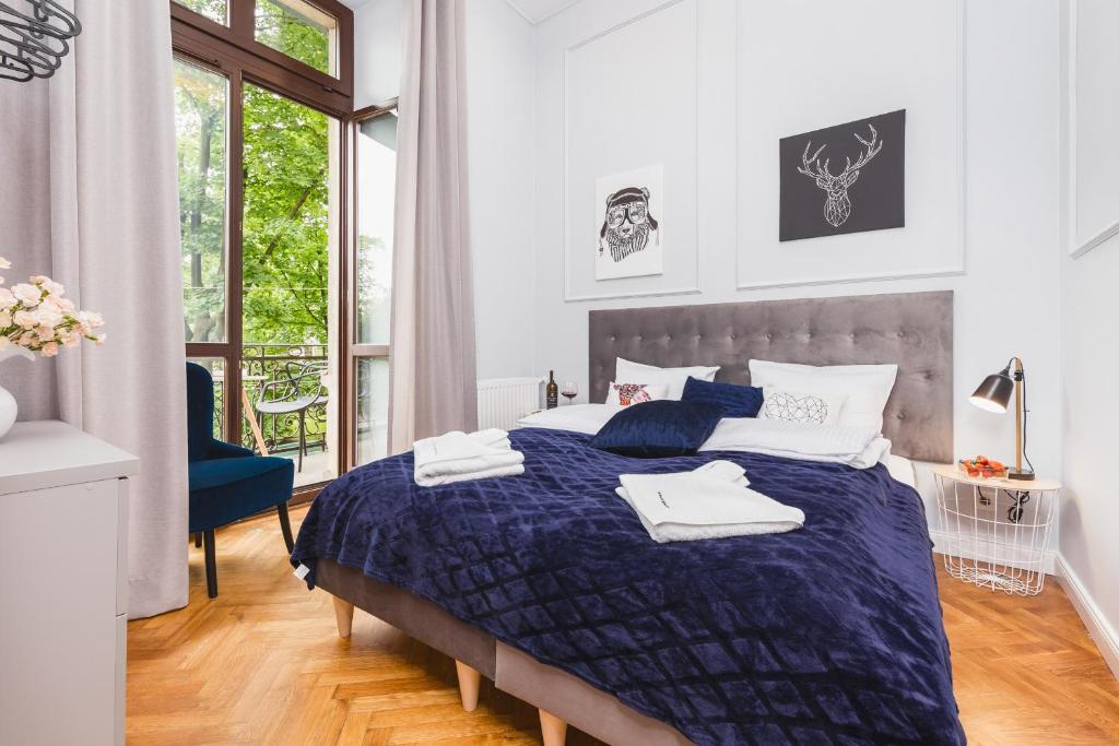 a bedroom with a bed with a blue comforter at The Old Town View in Kraków