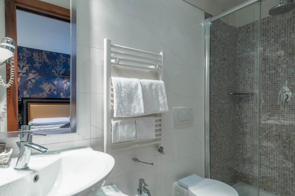 a white bathroom with a sink and a shower at Hotel Paganelli in Venice