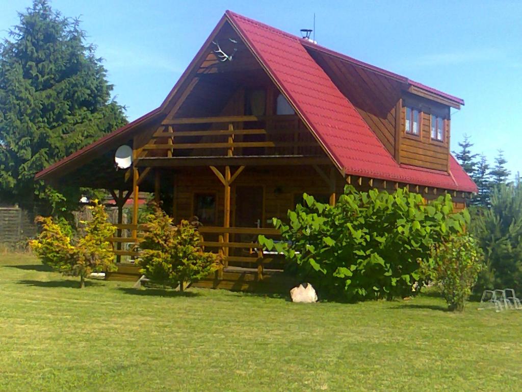 a large wooden cabin with a red roof at Ferien auf dem Lande in Leopoldshagen