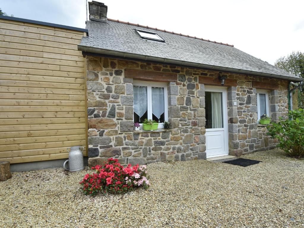 uma casa de pedra com flores em frente em Breton stone house in Saint Gilles les Bois em Saint-Gilles-les-Bois